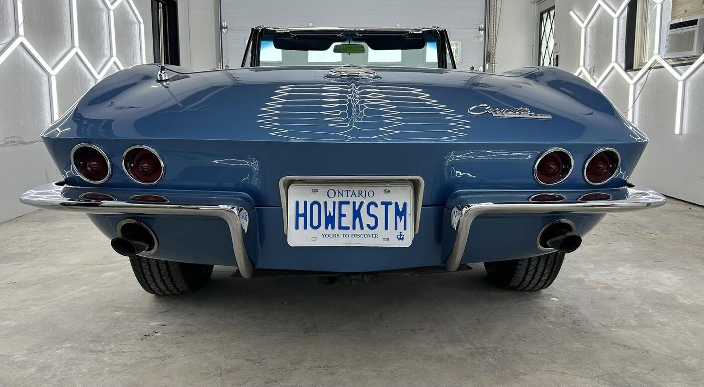 Rear of a blue Corvette convertible showing its stainless exhaust tips